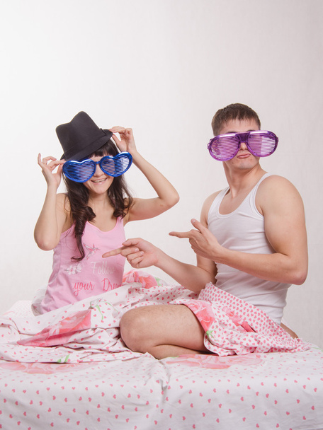 Молода пара сидить у ліжку з великими окулярами
 - Фото, зображення