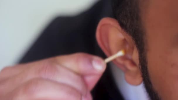 Человек чистит грязное ухо ватными тампонами - Кадры, видео