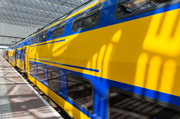 Grand train jaune dans une gare néerlandaise
 - Photo, image