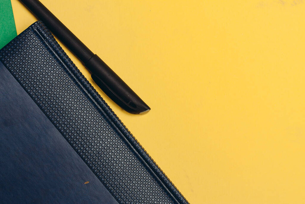 office supplies business finance notepad pens on yellow green background - Foto, Bild