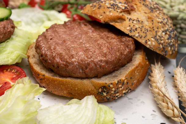 Preparare gustosi hamburger vegani vegetariani a base di hamburger di soia a base vegetale, panino biologico con semi e verdure fresche dell'orto. - Foto, immagini