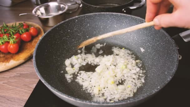 Gefrituurde uiengerechten footage.close-up gesneden uienstukken gebakken op pan in de keuken. Braaduien in zonnebloemolie in een hete pan.  - Video