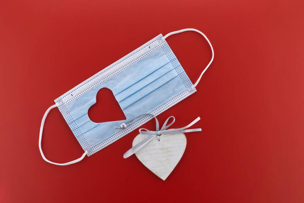 Маска для лица с вырезанным сердцем на красном фоне с бесплатным копированием - Фото, изображение