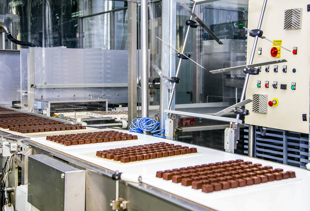 Een snoepfabriek. Sweets productieproces. Transportband met snoepjes erop. - Foto, afbeelding