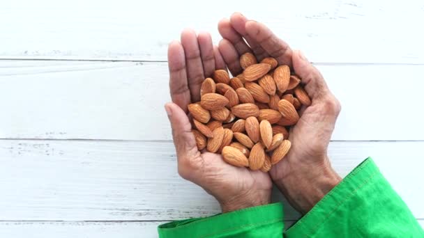 close up senior women hand holding a bowl on almond  - Footage, Video