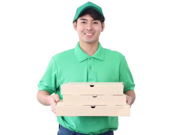 Mosolygó fiatal ázsiai futár zöld póló egyenruha és sapka tartó pizza dobozok elszigetelt fehér háttér, nyomon követése, szállítási és futár szállítási szolgáltatások expressz koncepció. - Fotó, kép