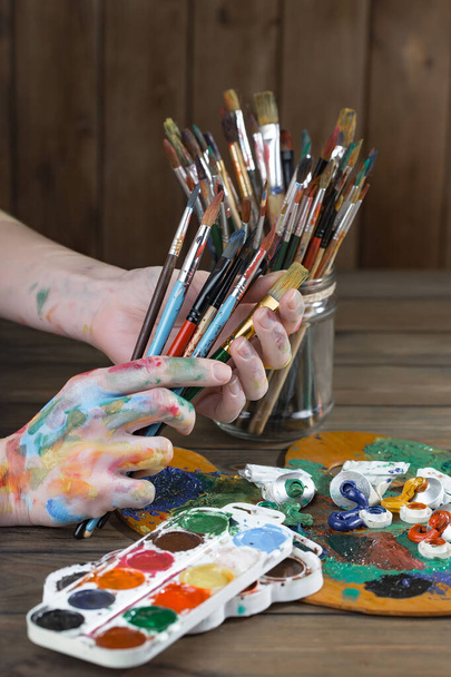 Női kéz a művész, ecsetek és festékek rajz. - Fotó, kép