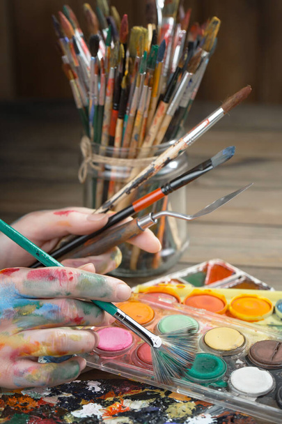 Frauenhände des Künstlers, mit Pinseln und Farben zum Zeichnen. - Foto, Bild
