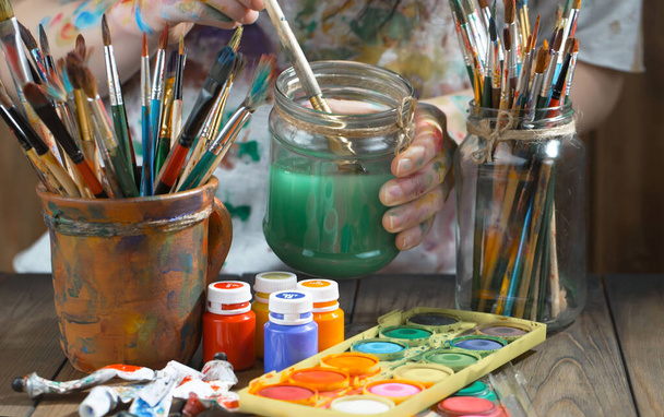 Női kéz a művész, ecsetek és festékek rajz. - Fotó, kép