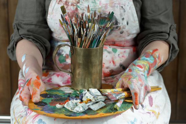 Mains féminines de l'artiste, avec pinceaux et peintures pour dessin. - Photo, image