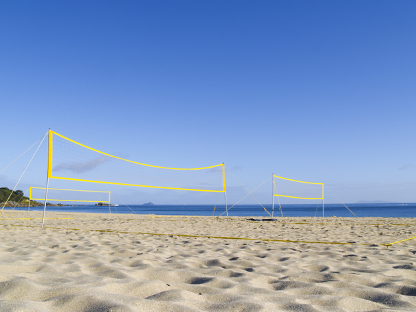 Redes amarillas de voleibol playa erigidas para su uso sin jugadores aún en el Monte Maunganui Playa principal. - Foto, imagen