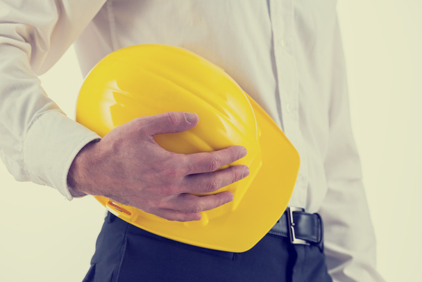 Empresário segurando um chapéu amarelo
 - Foto, Imagem