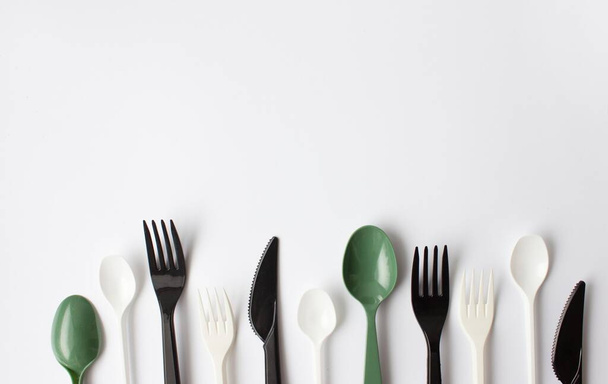 Color plastic cutlery on a white background. Place for text. Environmental problem, environmental pollution.  - Photo, Image