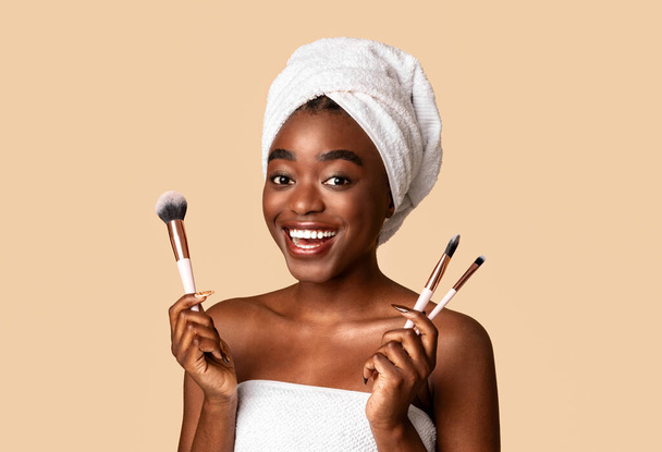 Porträt der schönen schwarzen Frau mit Make-up-Pinseln - Foto, Bild
