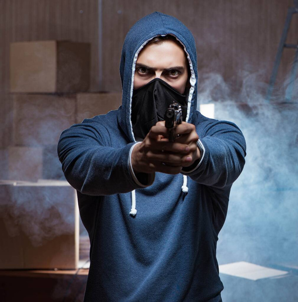 Agressieve man met een pistool met gezichtsmasker - Foto, afbeelding