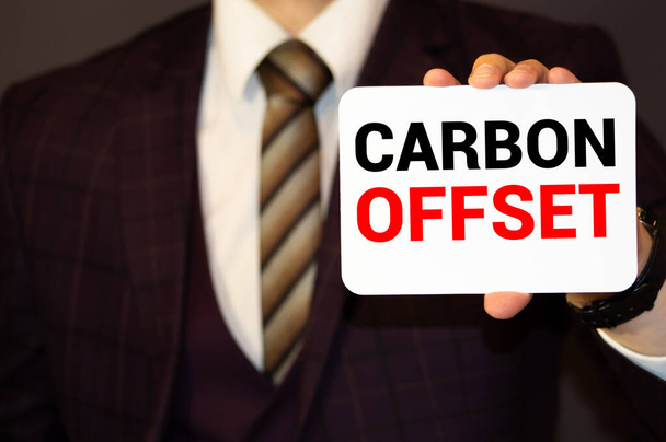 Tekstiä kirjoitetaan Carbon Offset. Liiketoiminta-ajatus hiilidioksidi- tai muiden kaasupäästöjen vähentämiseksi. - Valokuva, kuva
