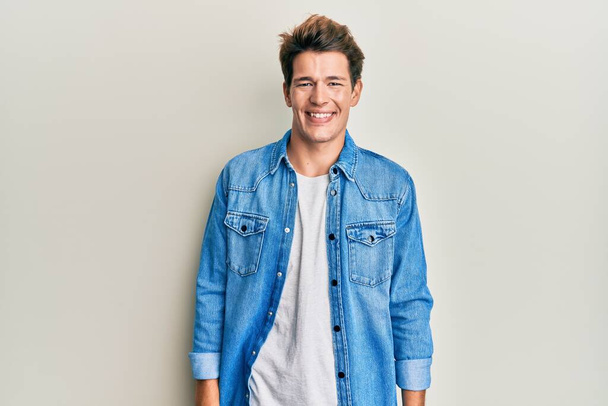 Handsome caucasian man wearing casual denim jacket with a happy and cool smile on face. lucky person.  - Photo, Image