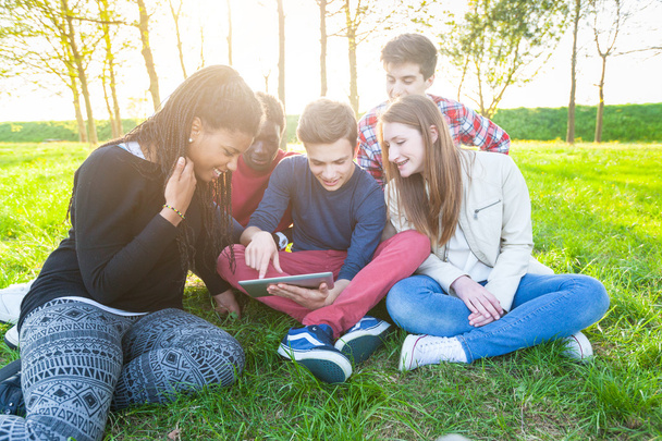 Teenage Friends using Digital Tablet at Park - Foto, Bild