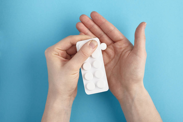 Weiße Blisterverpackung mit Medikamententabletten in einer Hand. Haufen Pillen - medizinischer Hintergrund - Foto, Bild