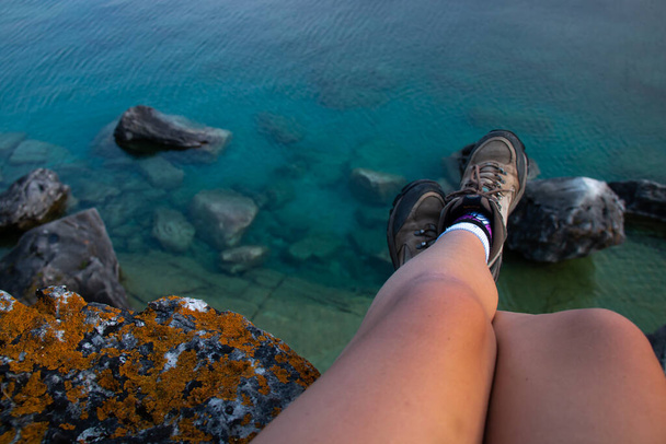 ハイカーのブーツと岩の露頭は、カナダのオンタリオ州ブルース半島国立公園の洞窟の近くにあるエレガントなサンバースト地衣類です(グルジア湾)).  - 写真・画像