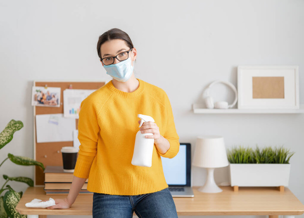 Woman in facemask working in home office. - Foto, afbeelding