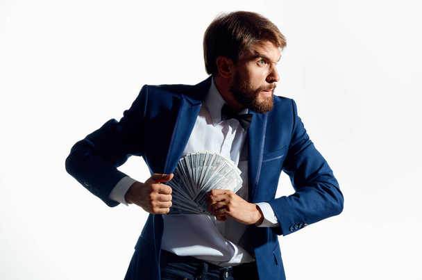 mężczyzna w klasycznym garniturze z kupą banknotów model finansowania biznesu - Zdjęcie, obraz