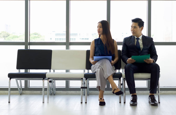 Asian business people waiting for job interview. Both of them looking at the same direction. - Photo, Image