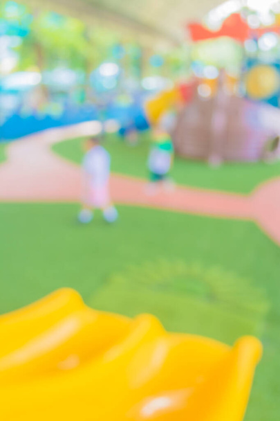 Defokussiertes und verschwommenes Bild des Kinderspielplatzes im öffentlichen Park zur Hintergrundnutzung. - Foto, Bild