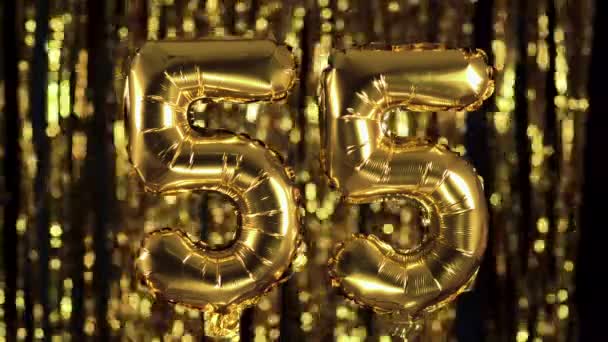 The golden number 55 fifty five is made from an inflatable balloon on a yellow background. One of the complete set of numbers. Birthday, anniversary, date concept - Footage, Video