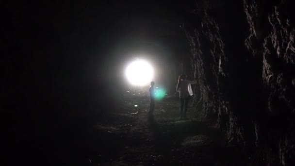 Fény egy hosszú barlang végén és gyerekek. - Felvétel, videó