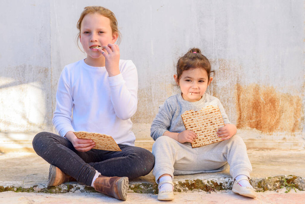 Two cute girl eating flatbread outdoor rural background. - Photo, Image