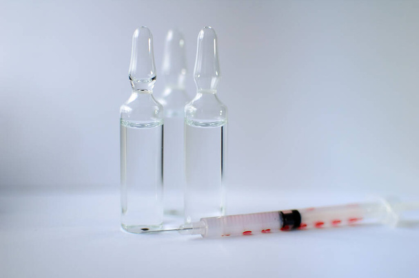 Ampułki medyczne i strzykawka insulinowa izolowane na białym tle, koncepcja szczepień - Zdjęcie, obraz