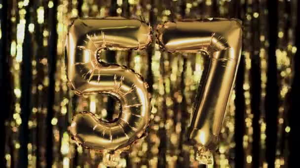 The golden number 57 fifty seven is made of an inflatable balloon on a yellow background. One of the complete set of numbers. Birthday, anniversary, date concept - Footage, Video
