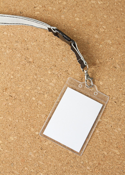 Blank badge with neckband on corkboard background. - Photo, Image