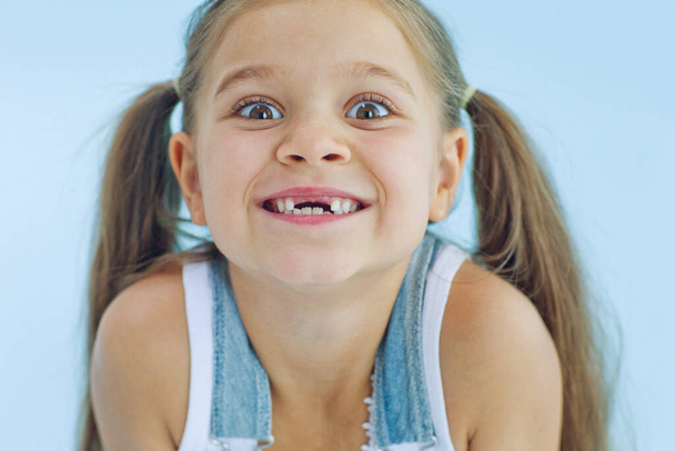 Retrato de niña preescolar con la boca abierta sin diente de leche. - Foto, Imagen
