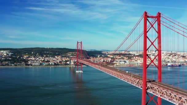 Widok z lotu ptaka lub nagranie drona z mostu 25 de April. Czerwony most łączy Lizbonę z Almadą w Portugalii. Rzeka Tagus. - Materiał filmowy, wideo