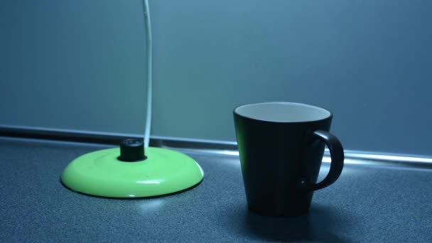 Váltás a vízforraló és behelyez egy teafiltert egy pohárba a konyhapulton - Felvétel, videó