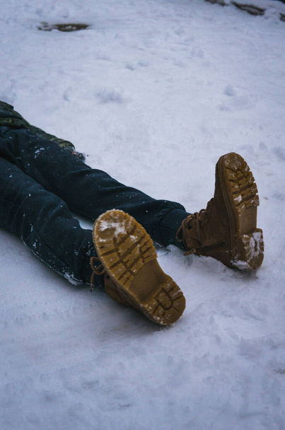 Gambe con scarponi sdraiate sulla neve - Foto, immagini