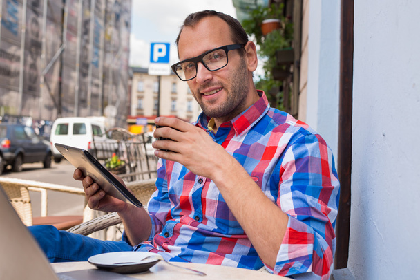 Man using tablet and drinking coffee - Фото, изображение