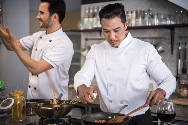 Two chefs preparing food in the kitchen of a restaurant  - Photo, Image