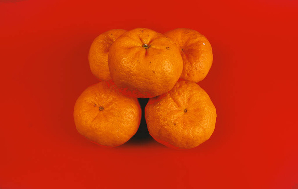 5 naranjas de mandarín para la celebración del año nuevo chino y la decoración sobre fondo rojo - Foto, Imagen