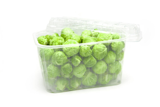 Organic brussels sprouts in disposable plastic container isolated on white background. - Photo, Image