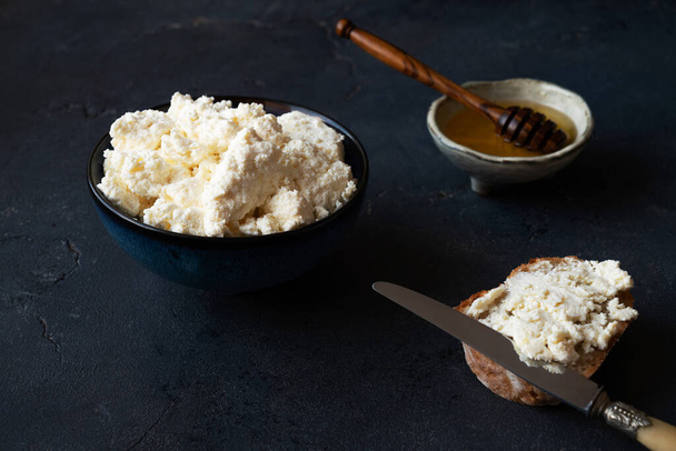 Home made fresh ricotta cheese, quark, cottage cheese, fromage frais with honey and bread. High angle. - Photo, Image