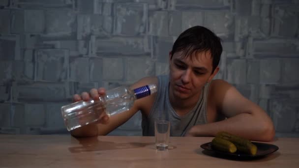 alcohólico bebiendo vodka con dolor sentado a la mesa - Imágenes, Vídeo