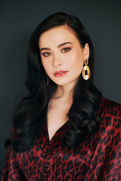 Modeporträt der schönen asiatischen Frau, professionelles Make-up und Hairstyling, trägt Kleid mit Leopardenmuster - Foto, Bild