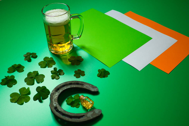 fer à cheval chanceux avec groupe de couvertures à trois feuilles et pot d'or liquide, bière et drapeau d'Irlande sur fond vert - Photo, image
