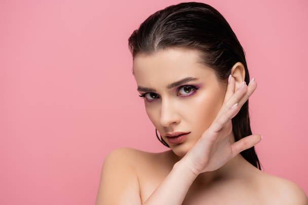 sensual woman with makeup and bare shoulders looking at camera isolated on pink - Photo, Image