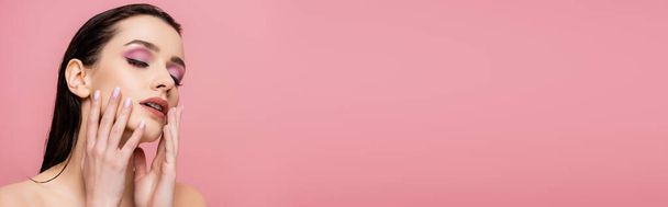 молодая женщина с голыми плечами и макияжем трогательное лицо изолированы на розовый, баннер - Фото, изображение