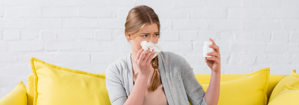 Woman with allergy holding napkin and pills at home, banner  - 写真・画像