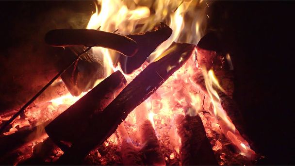 Ψήσιμο λουκάνικο σε ένα ξύλινο ραβδί πάνω από τη φωτιά, τζάκι - Φωτογραφία, εικόνα